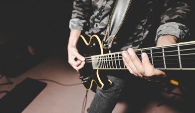 Black electric guitar being played