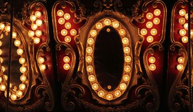Elaborate gold and red mirror surrounded with yellow lights