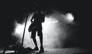 Musician on stage with white backlight