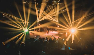 Performers and crowd surrounded by yellow stage lights