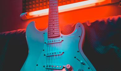 White electric guitar in neon red light