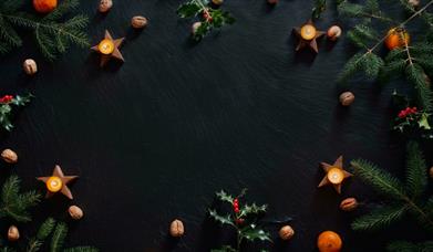 Candles and Christmas decorations on slate background