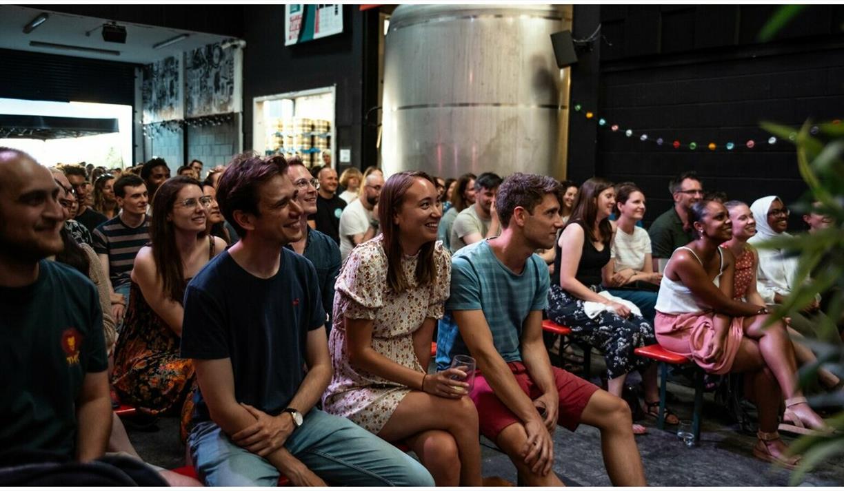 An audience laughing