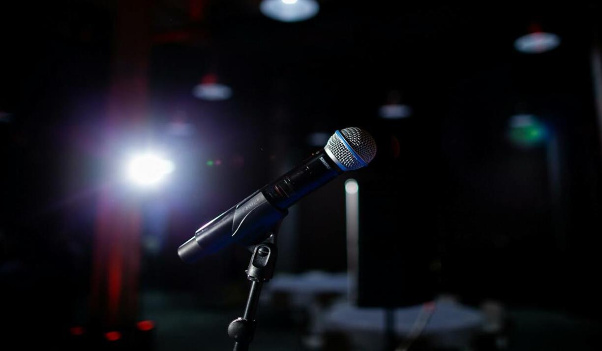 Microphone on a dark stage with spotlight in background