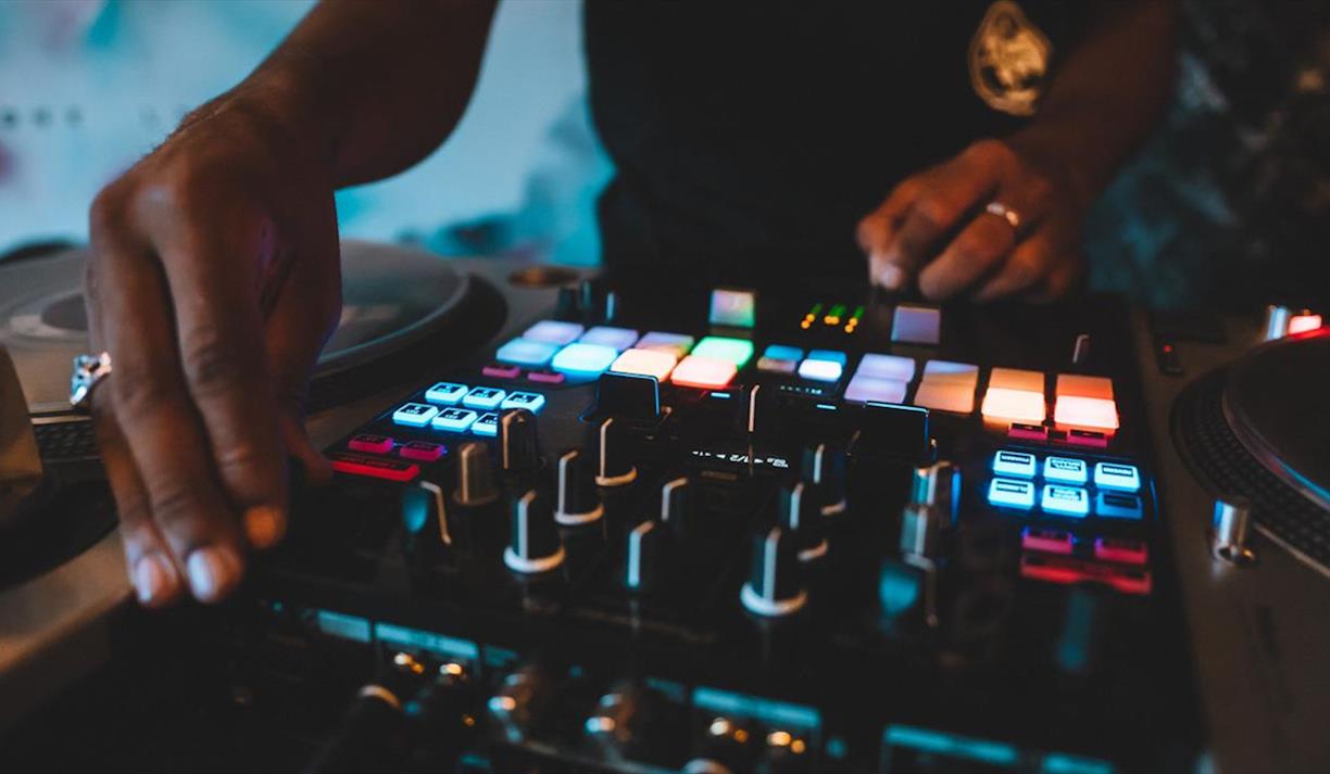 DJ using a turntable with multicoloured lights