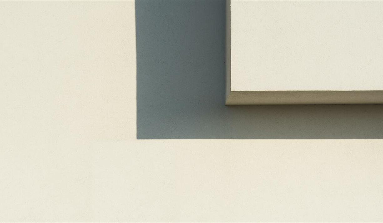 Minimalist image of geometric shadows on a white wall