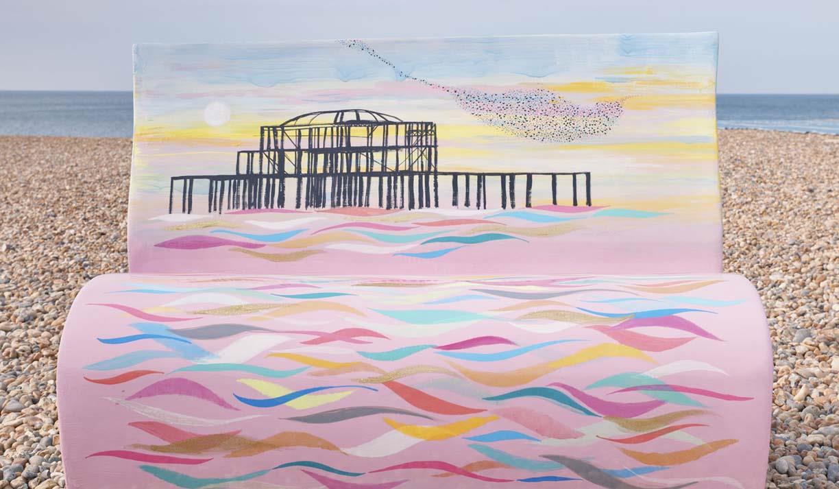 Bench sculpture on the pebbles painted with an image of Brighton' West Pier