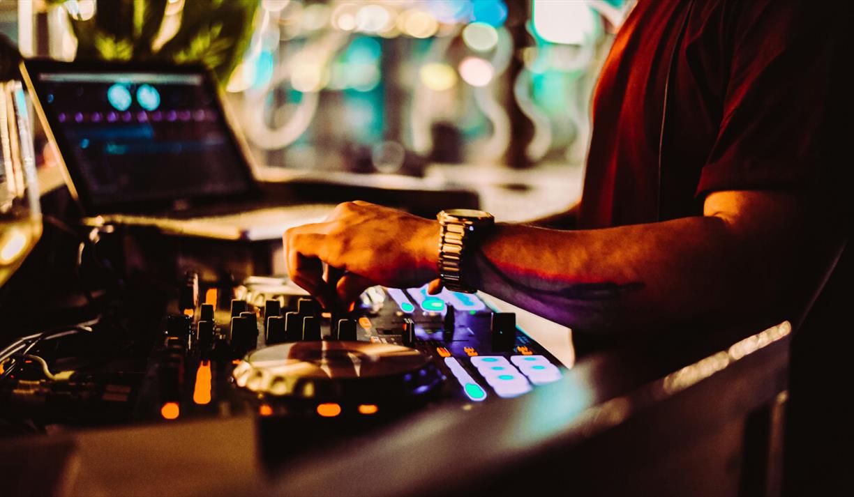 Warm toned image of a mixing desk and laptop