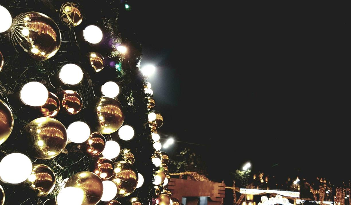 Gold and silver baubles displayed on the wall of an outdoor display