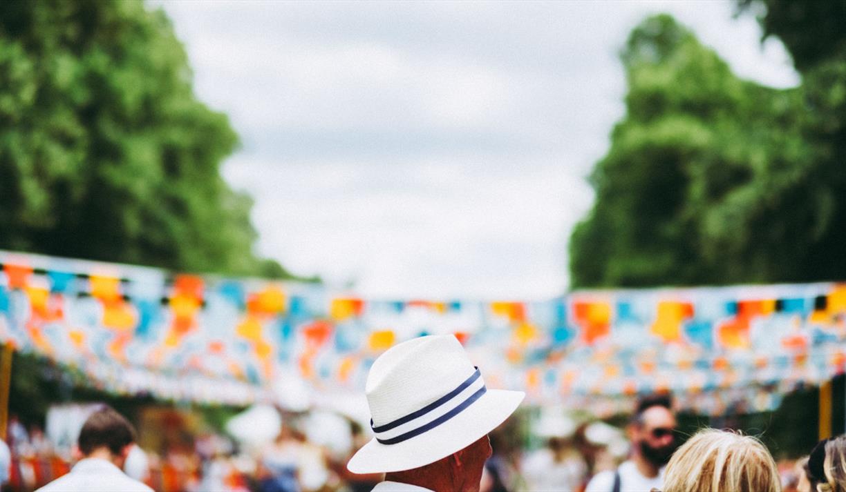 Person in white hat in front of blue and orange bunting