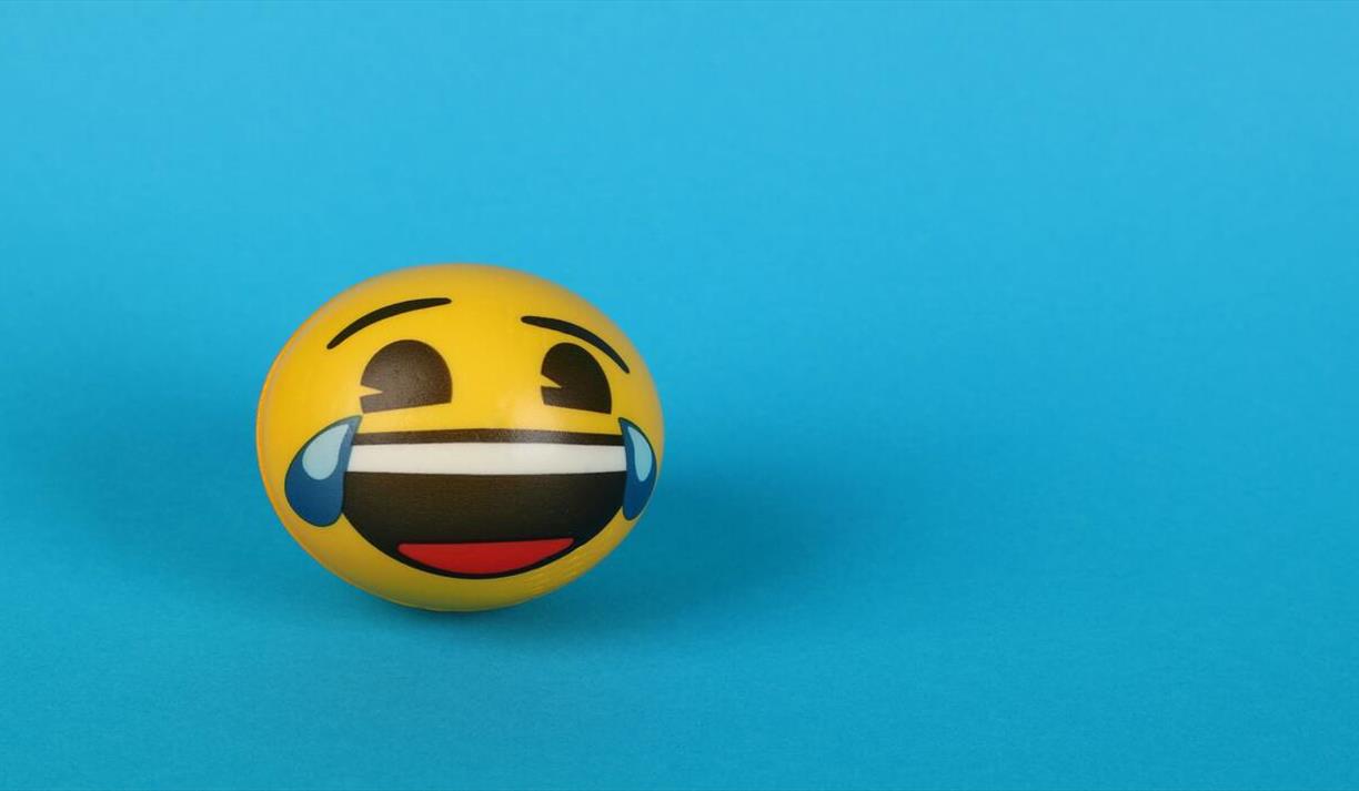 Laughing emoji face on a blue background