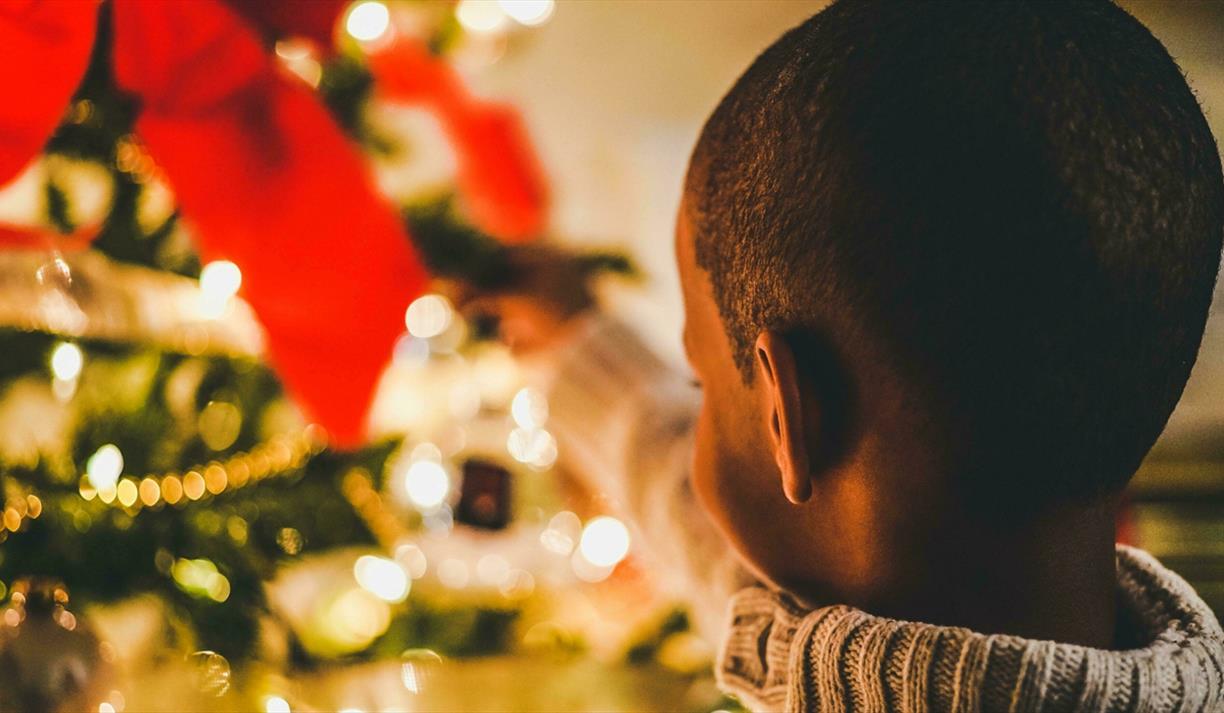 Small child close to Christmas tree