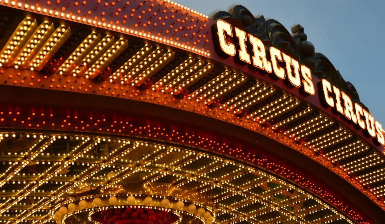 Circus roof sign surrounded by yellow and red lights