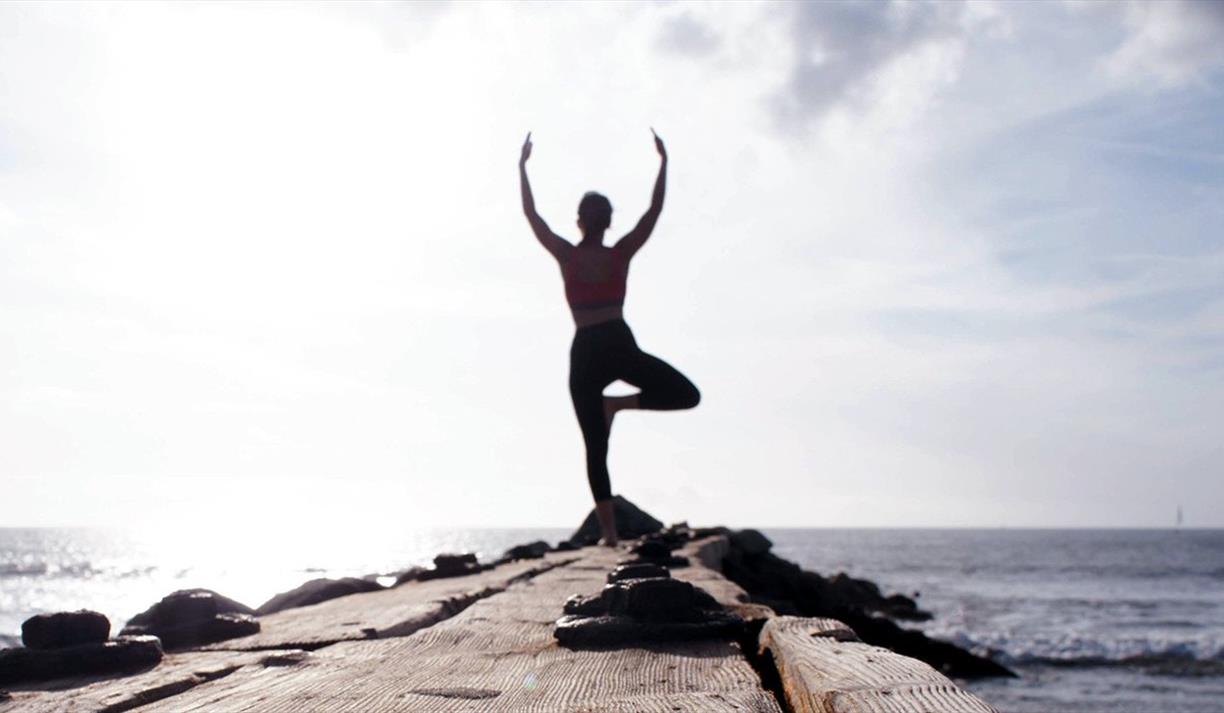 Woman doing yoga by the sea