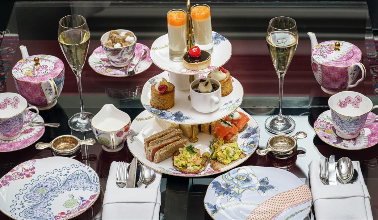 An afternoon tea with cakes and flowery pink tea set