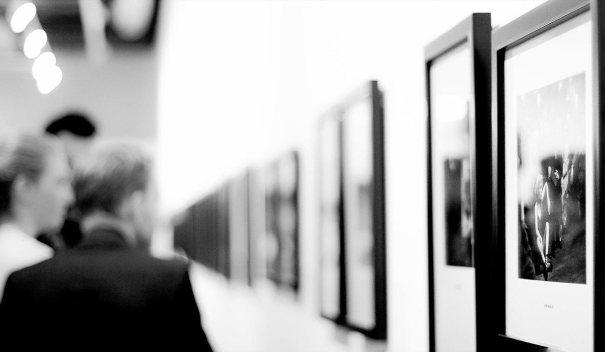 People looking at art on a wall