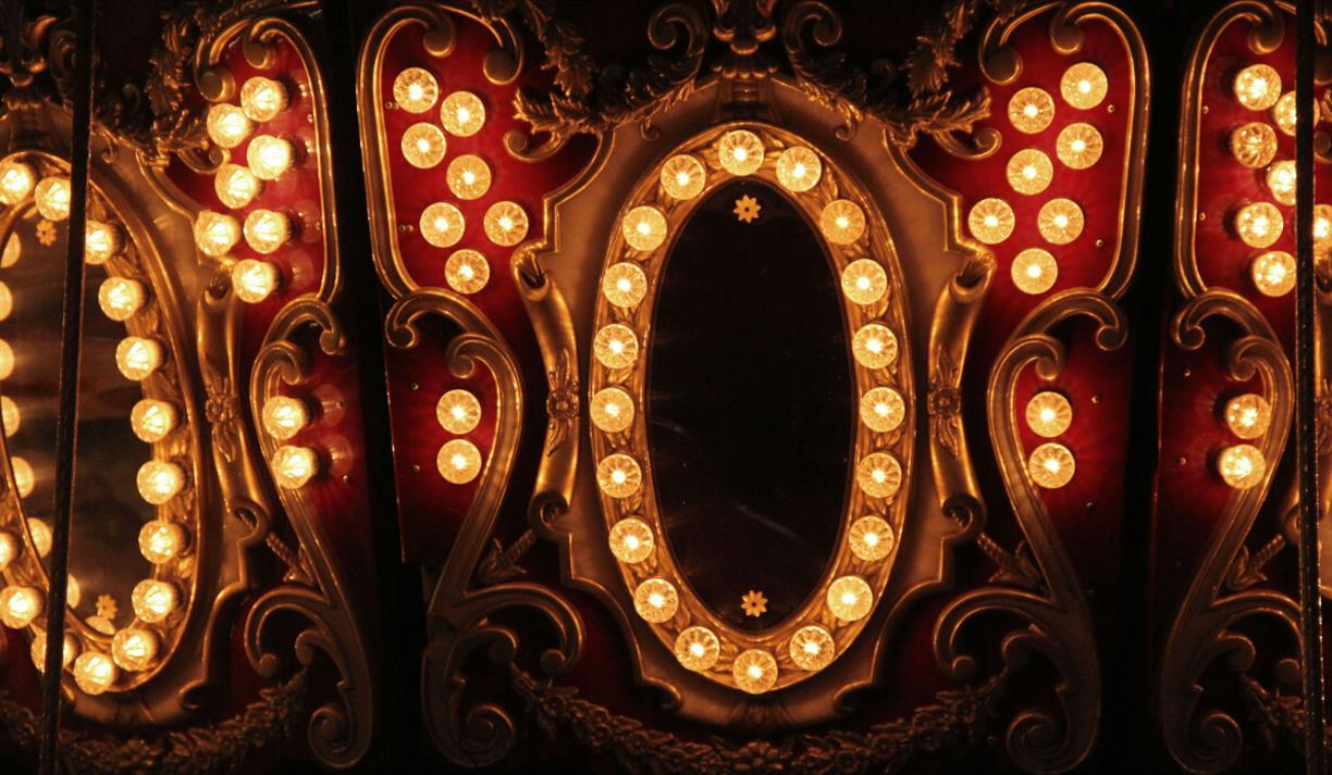 Elaborate gold and red mirror surrounded with yellow lights