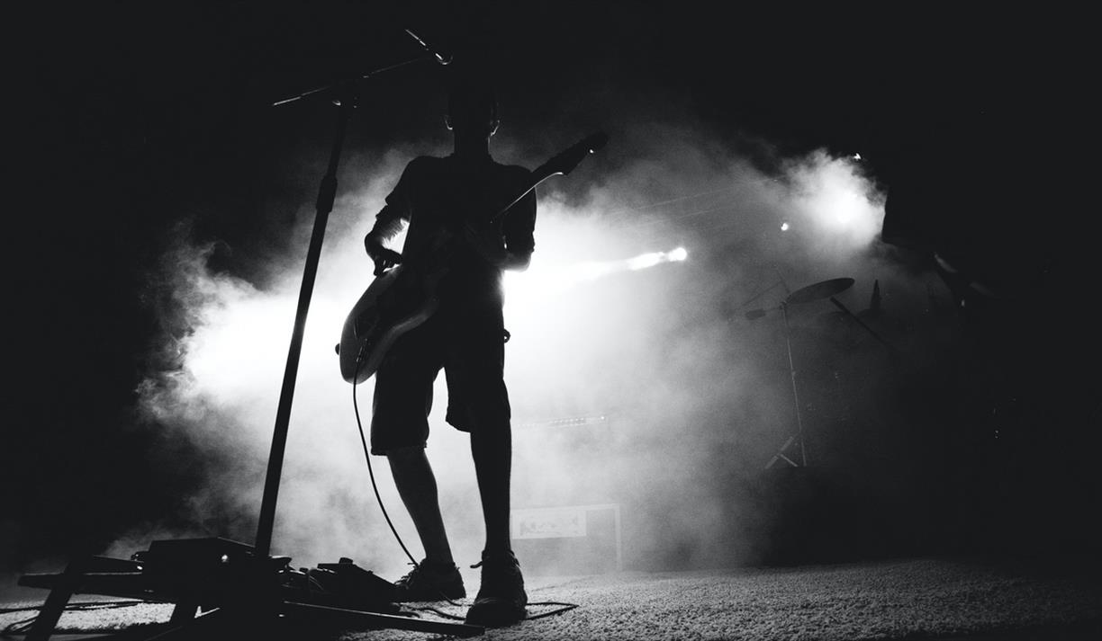 Musician on stage with white backlight