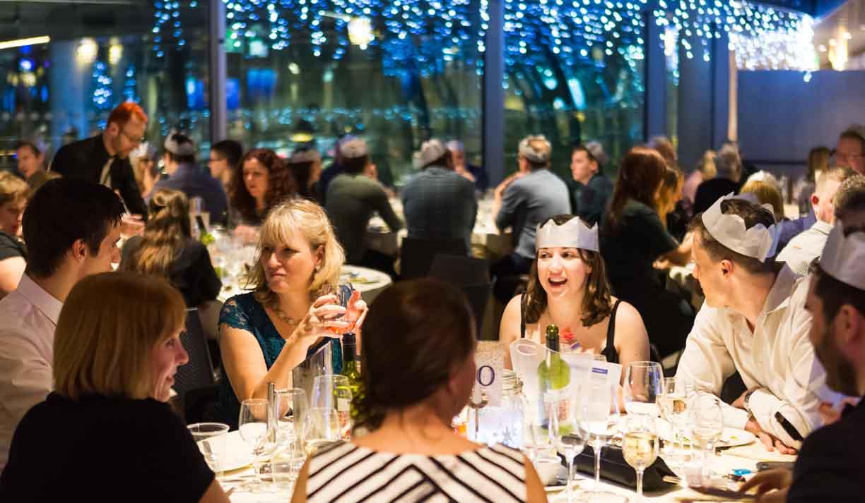 A group of people sitting at a table within the pod of the Brighton i360