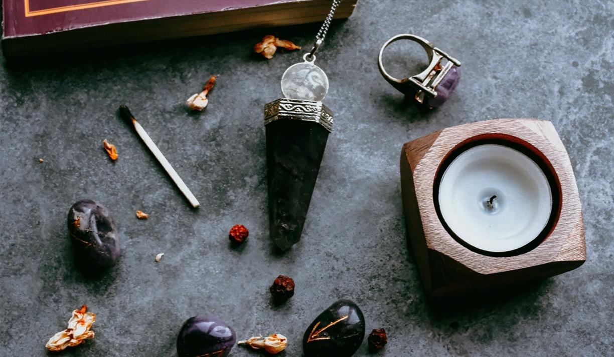 Crystals and candles on a grey marble surface