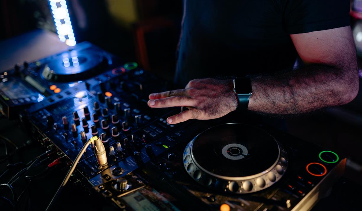 DJ on decks with square watch
