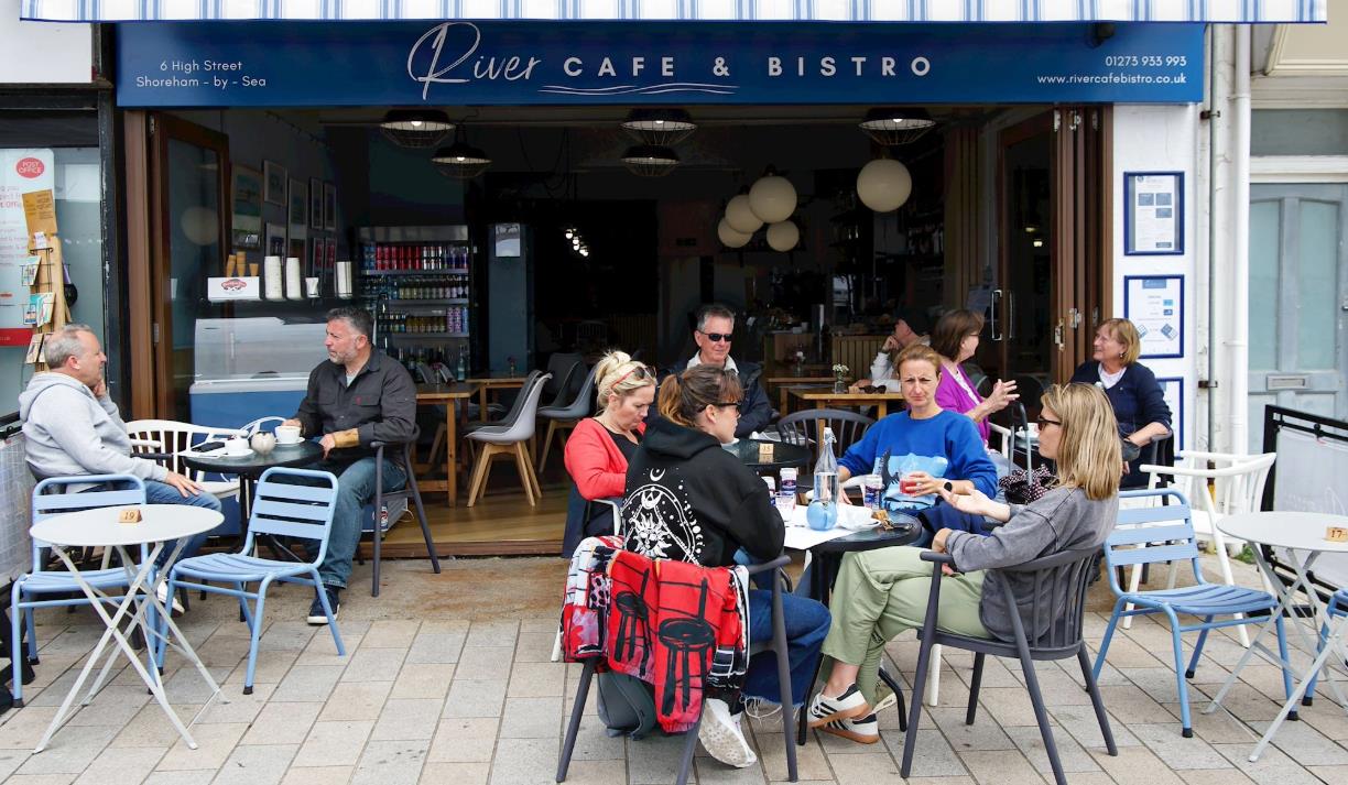 Tables outside the cafe of visitors enjoying the food and views.