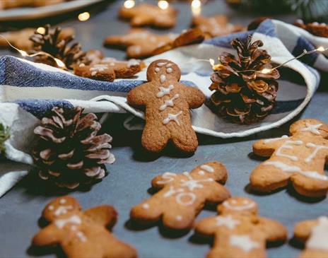 Gingerbread men surrounded with pinecones and string lights