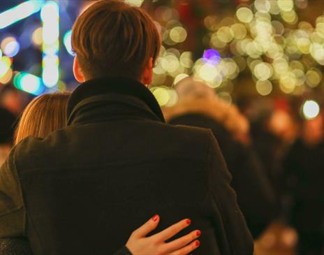 Couple looking out over Christmas outdoor gathering