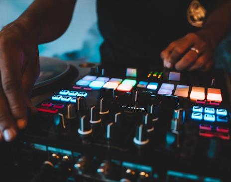 DJ using a turntable with multicoloured lights