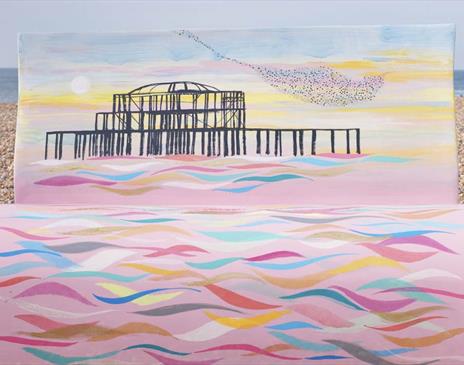 Bench sculpture on the pebbles painted with an image of Brighton' West Pier