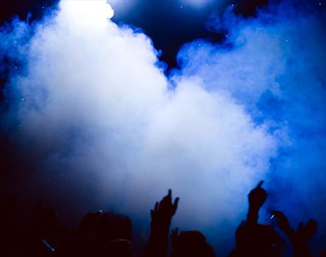 People with arms in the air in a club