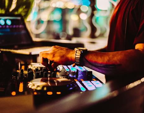 Warm toned image of a mixing desk and laptop