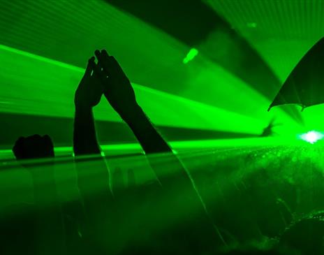 Sea of green lights and hands raised in the air