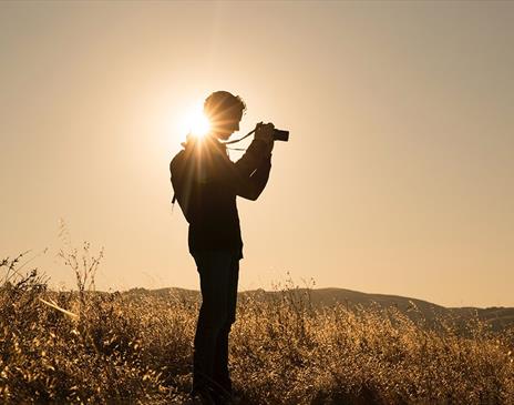 Person taking photographs in an empty field