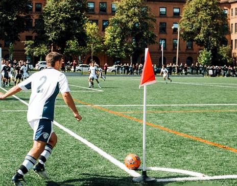 Man playing in a football match doing a corner kick