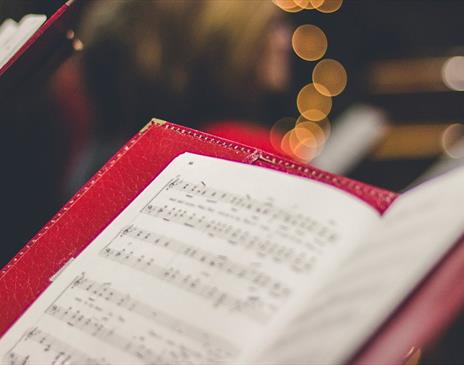 Carolers holding music song books