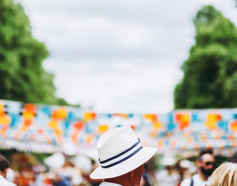 Person in white hat in front of blue and orange bunting
