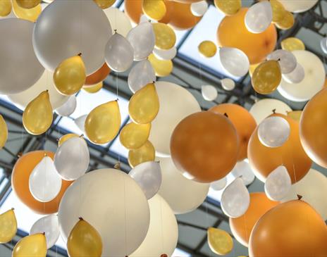White and gold balloons tied to a string