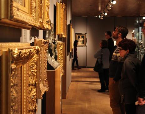 Patrons looking at art in gold frames