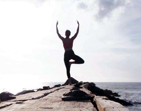 Woman doing yoga by the sea