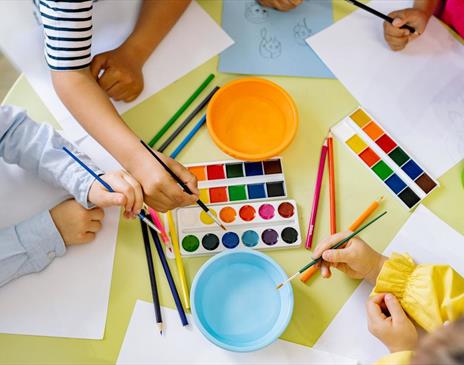 Children using pencils paint and colourful paint