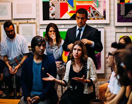 Group of people having a discussion with art on walls behind them