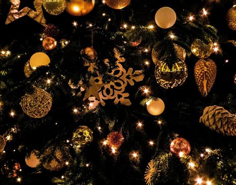 Christmas tree decorated with golden baubles and pinecones