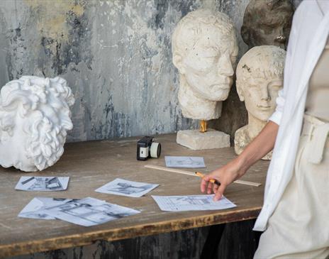 A selection of sketches and white sculptures on a table