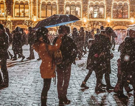 Busy and snowy cobbled street