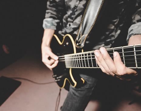 Black electric guitar being played