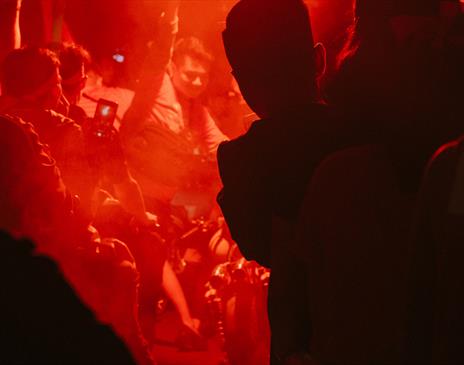 Dancers in orange lit night club