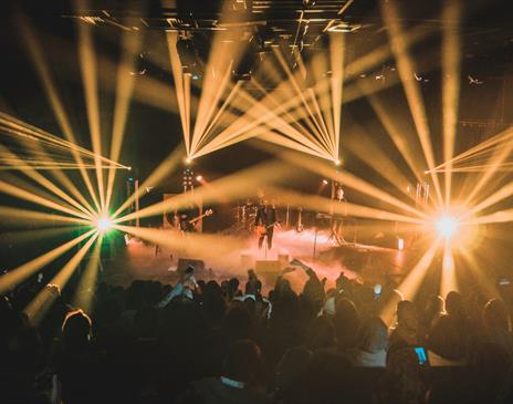 Performers and crowd surrounded by yellow stage lights