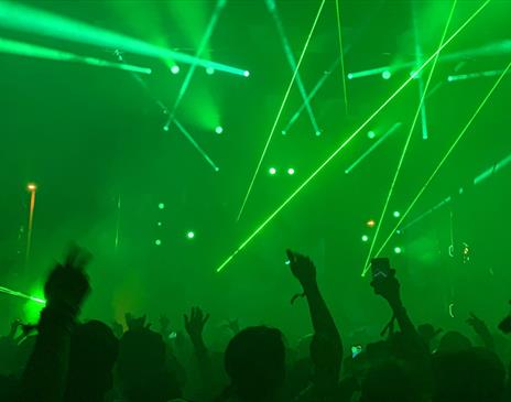 Green room with crowd and white strobe lights