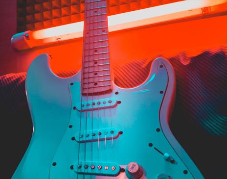 White electric guitar in neon red light